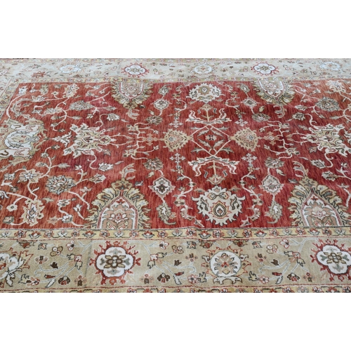 240 - An Indian Agra carpet, traditional floral design on terracotta field, beige rosette border, 274 cm x... 