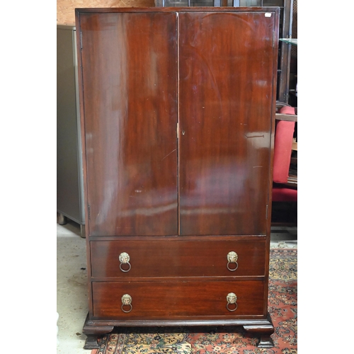 267 - #A two door cupboard with shelved interior and two drawers with lion mask brass handles, 82 x 40 x 1... 