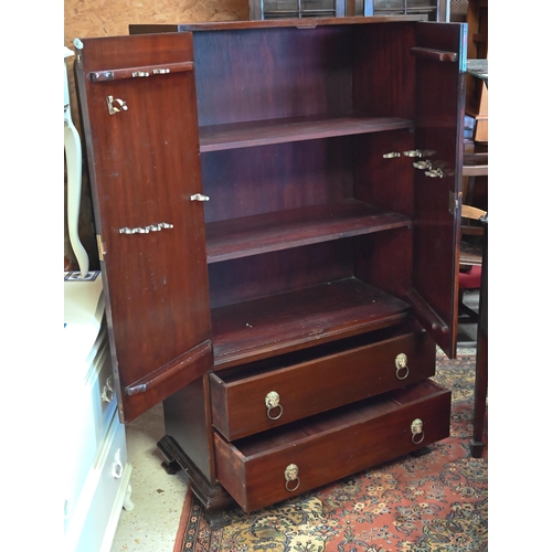 267 - #A two door cupboard with shelved interior and two drawers with lion mask brass handles, 82 x 40 x 1... 