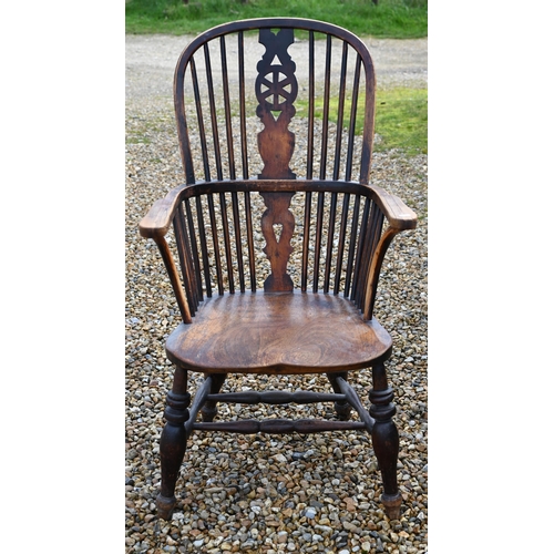 270 - An elm seated wheelback Windsor elbow chair, turned supports and stretcher