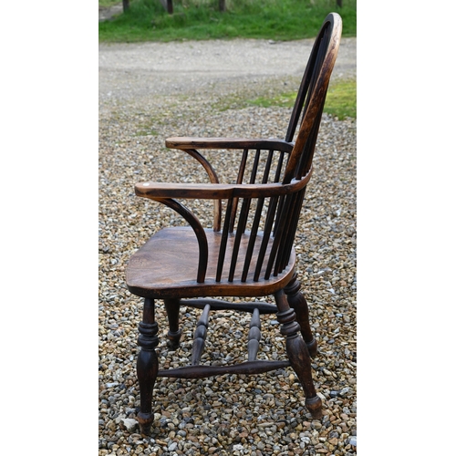 270 - An elm seated wheelback Windsor elbow chair, turned supports and stretcher