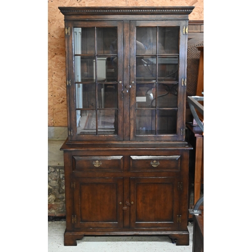 271 - A reproduction oak cabinet bookcase, the top section with astragal glazed doors enclosing shelves on... 