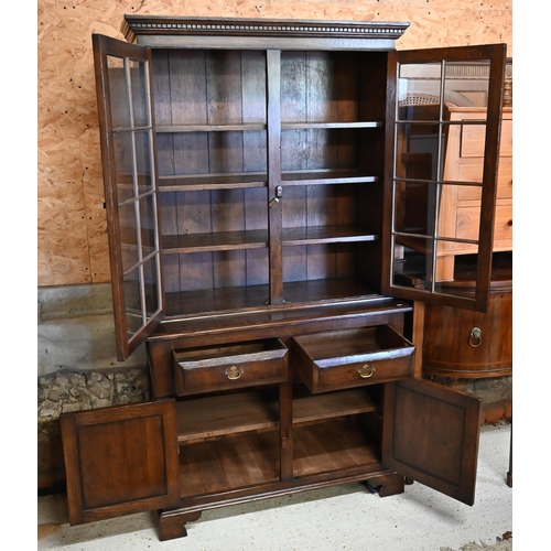 271 - A reproduction oak cabinet bookcase, the top section with astragal glazed doors enclosing shelves on... 