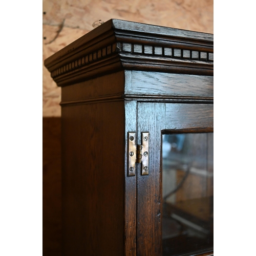 271 - A reproduction oak cabinet bookcase, the top section with astragal glazed doors enclosing shelves on... 