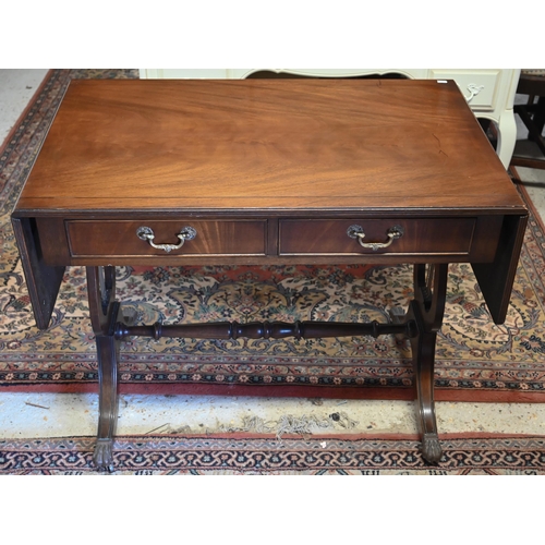 272 - A Regency style mahogany sofa table with two drawers, lyre supports and brass paw castors, 90 x 55 x... 