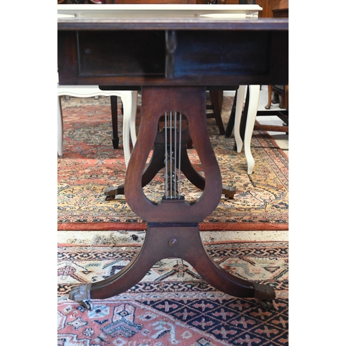 272 - A Regency style mahogany sofa table with two drawers, lyre supports and brass paw castors, 90 x 55 x... 