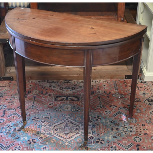 276 - #A 19th century mahogany demi-lune tea table, re-stained folding top, moulded supports and brass cas... 