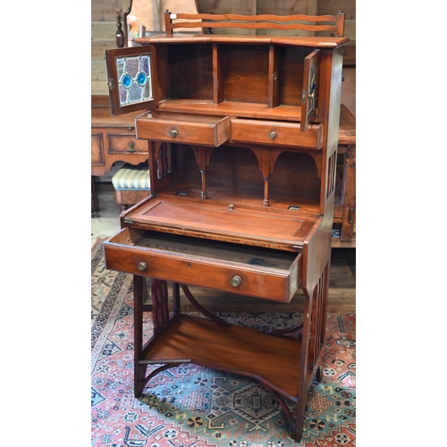 282 - A 20th century Liberty style Arts & Crafts writing desk with leaded stained glass doors, three d... 