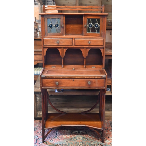 282 - A 20th century Liberty style Arts & Crafts writing desk with leaded stained glass doors, three d... 