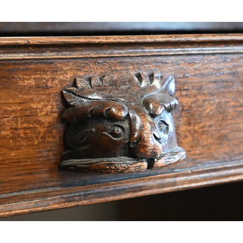 307 - A late Victorian Gothic Revival carved oak twin pedestal desk with nine drawers and 'Green Man' carv... 