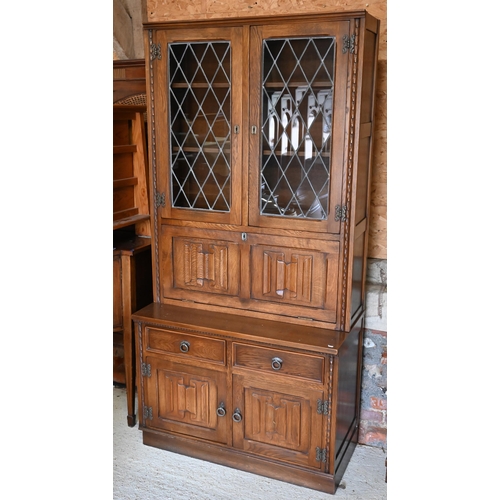 315 - Jaycee Furniture Ltd (Brighton) a companion pair of linenfold panelled oak wall units, one with latt... 