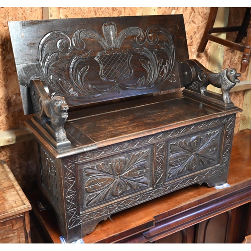 333 - A Gothic style oak monks' bench carved with armorial crest, foliate panels and roaring lion arms, 10... 