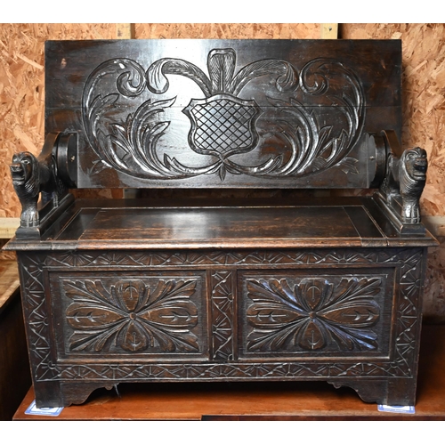 333 - A Gothic style oak monks' bench carved with armorial crest, foliate panels and roaring lion arms, 10... 