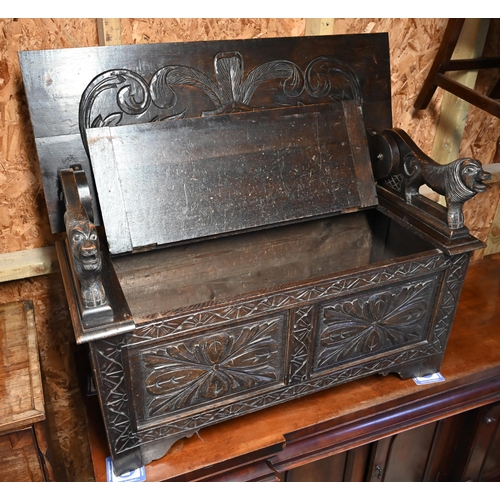 333 - A Gothic style oak monks' bench carved with armorial crest, foliate panels and roaring lion arms, 10... 