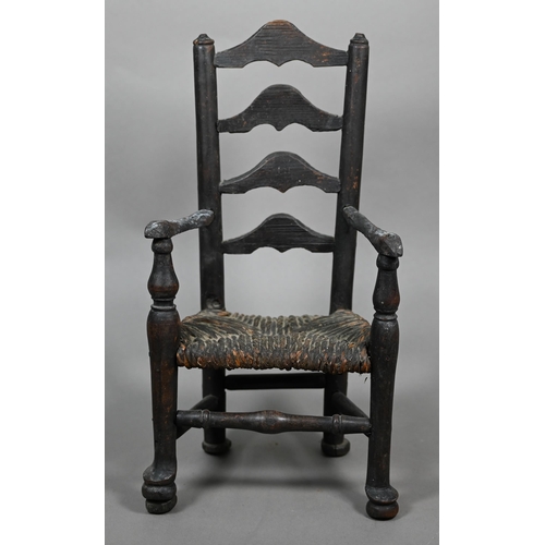 555 - An antique miniature ladderback armchair with rush seat, 35 cm