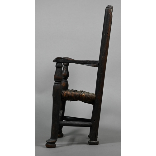 555 - An antique miniature ladderback armchair with rush seat, 35 cm