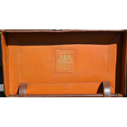 577 - A vintage leather suitcase by A Davis & Co, the Strand, London to/w two military issue leather-t... 