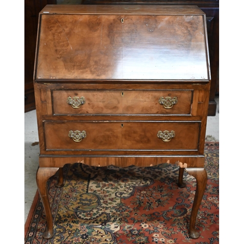 589 - A 1950s figured walnut bureau, with two drawers and raised on cabriole legs, 69 cm x 44 cm x 99 cm h