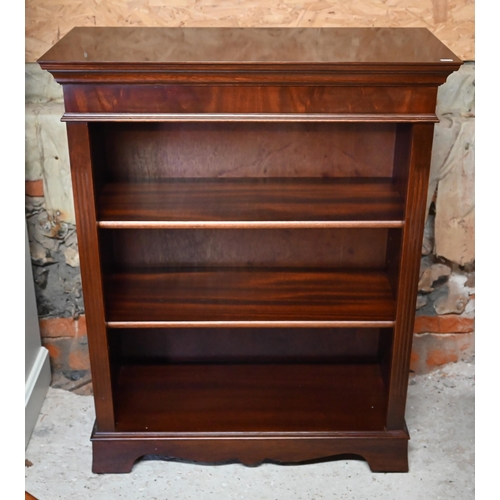 593 - A reproduction bright mahogany open three tier bookcase, on a wavy plinth base, 82.5 cm w x 37 cm x ... 