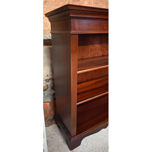 593 - A reproduction bright mahogany open three tier bookcase, on a wavy plinth base, 82.5 cm w x 37 cm x ... 