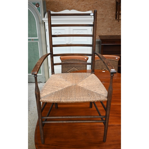 597 - A antique ladder back open armchair with rope seat