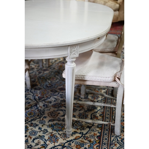 631 - A distressed off-white painted double d-end dining table and extension leaf, to/with a set of six di... 