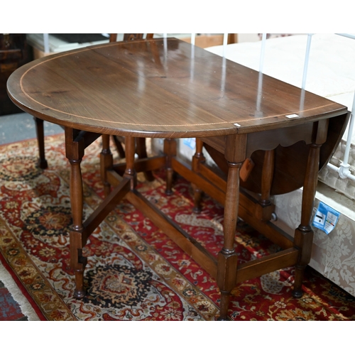 632 - #A traditional reproduction feather-banded gateleg oval dropleaf table, 114 cm x 137 cm (open) x 75 ... 