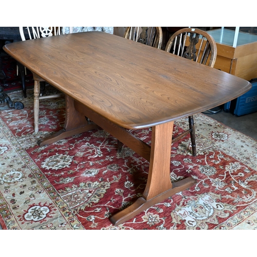 641 - An Ercol dark elm dining table on twin-trestle supports united by the central stretcher, 150 cm x 84... 