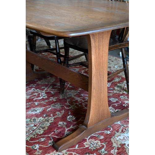 641 - An Ercol dark elm dining table on twin-trestle supports united by the central stretcher, 150 cm x 84... 