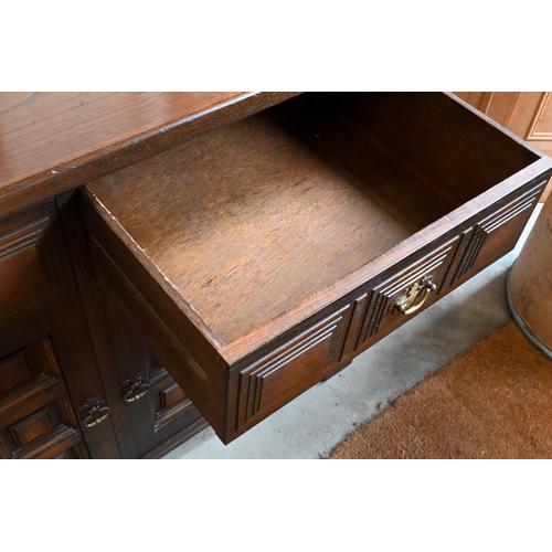 653 - A 'Younger' Toledo oak Spanish style sideboard with three frieze drawers above panelled doors, 157cm... 