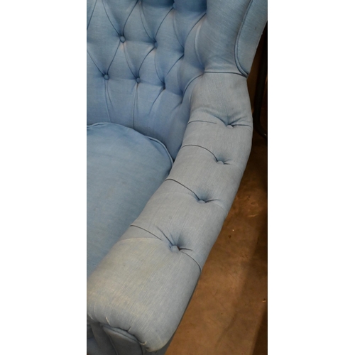 655 - A deep-buttoned armchair covered in blue twill fabric, on tapering supports