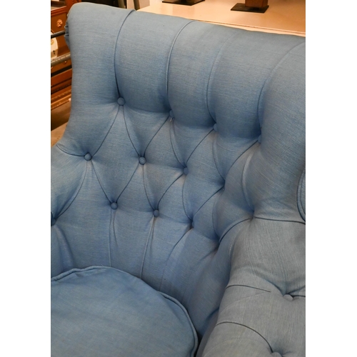 655 - A deep-buttoned armchair covered in blue twill fabric, on tapering supports