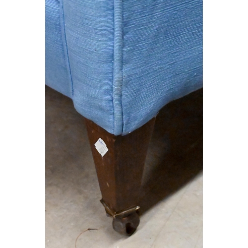 655 - A deep-buttoned armchair covered in blue twill fabric, on tapering supports