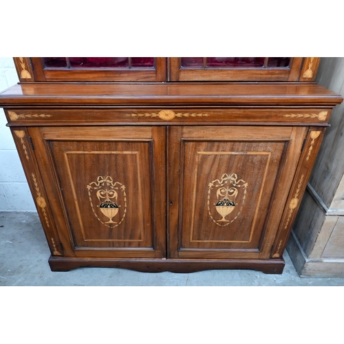 663 - An Edwardian inlaid mahogany cabinet bookcase with swan-neck moulded pediment above twin glazed door... 