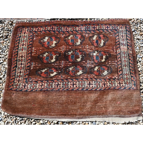 673 - An small antique Turkoman rug, 122 cm x 78 cm to/w a Turkoman bag face, 97 cm x 84 cm and a camel gr... 