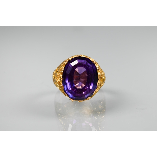 302 - A 1970s yellow metal ring of sculptural design inset with oval amethyst, size O, stamped k18, approx... 