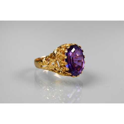 302 - A 1970s yellow metal ring of sculptural design inset with oval amethyst, size O, stamped k18, approx... 