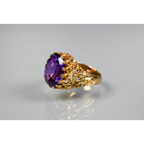 302 - A 1970s yellow metal ring of sculptural design inset with oval amethyst, size O, stamped k18, approx... 