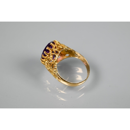 302 - A 1970s yellow metal ring of sculptural design inset with oval amethyst, size O, stamped k18, approx... 