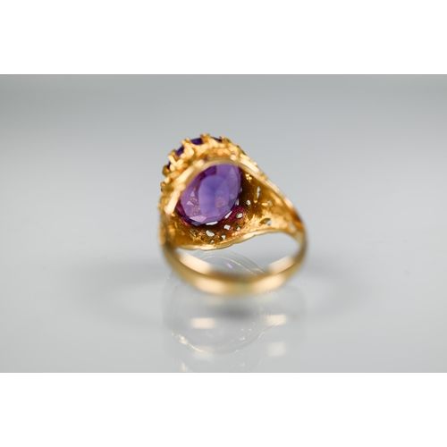 302 - A 1970s yellow metal ring of sculptural design inset with oval amethyst, size O, stamped k18, approx... 