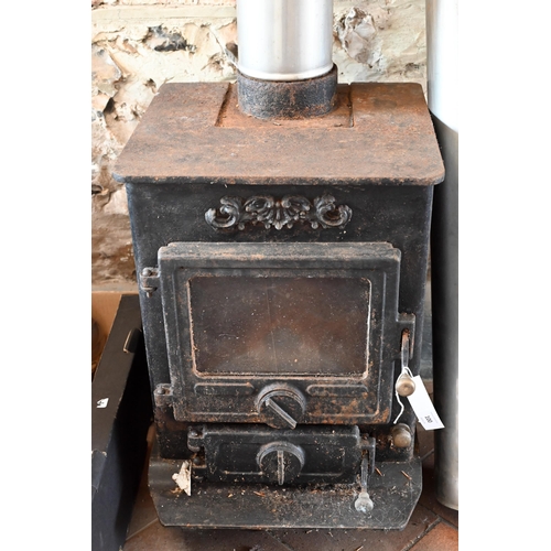 100 - A used cast iron wood burning stove, with two chimney sections - sold as removed