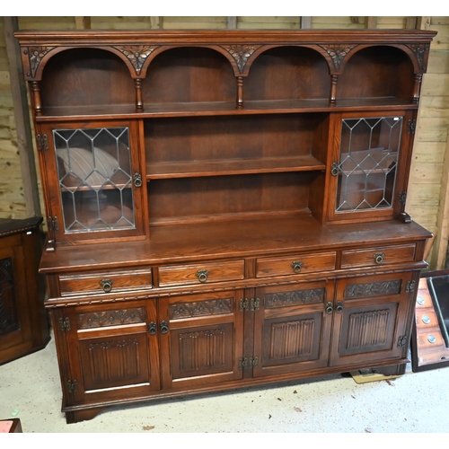 111 - An Old Charm oak high dresser, with part lead glazed doors over four drawers and carved cupboards, r... 