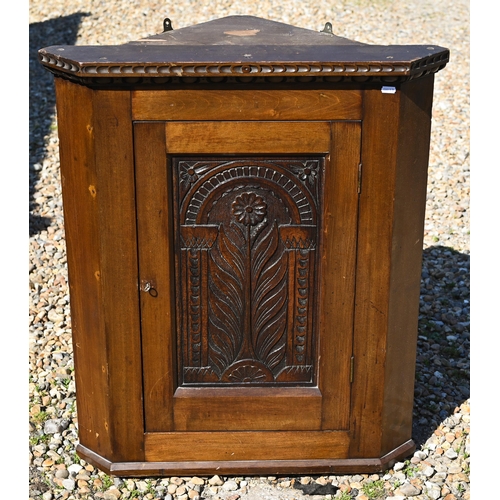 112 - An old oak hanging corner cupboard, with carved floral motif to the single door, 82 cm h