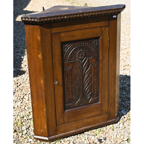 112 - An old oak hanging corner cupboard, with carved floral motif to the single door, 82 cm h