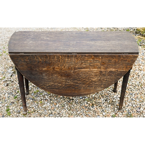 124 - A Georgian oak oval drop leaf gateleg supper table raised on paw feet, 115 cm x 47 cm (134 cm open) ... 