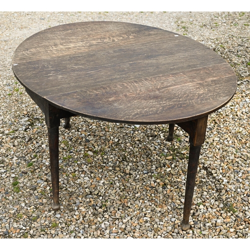 124 - A Georgian oak oval drop leaf gateleg supper table raised on paw feet, 115 cm x 47 cm (134 cm open) ... 