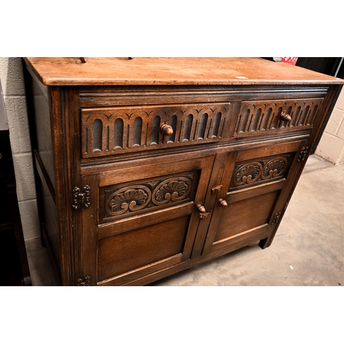 141 - An Old Charm style carved oak dresser with two drawers over panelled cupboard doors, 108 x 48 x 172 ... 