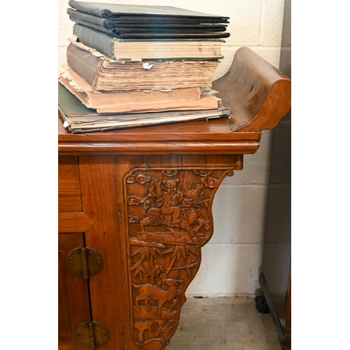 151 - A Chinese elm and brass mounted altar-top cabinet with two drawers and cupboards, decoratively carve... 