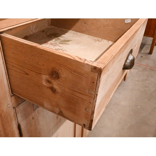 161 - A large Victorian stripped pine dresser with plate rack over three drawers and panelled cupboards (a... 