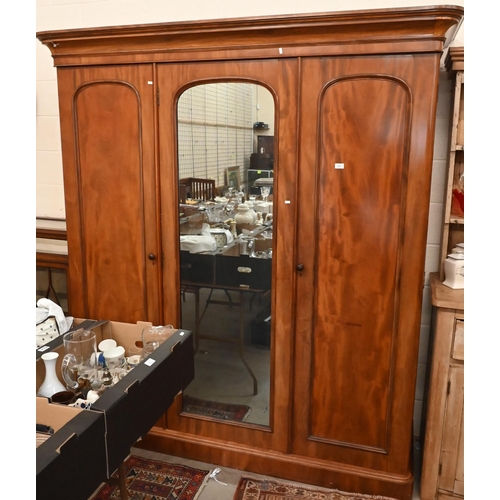 162 - A Victorian mahogany wardrobe with mirrored and panelled full length doors enclosing hanging rails a... 